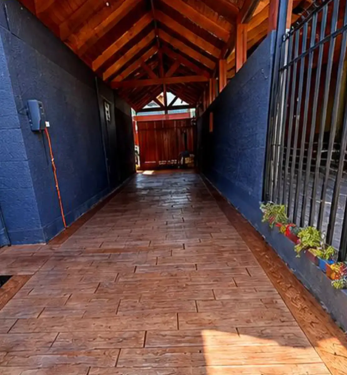 Pasillo techado con hormigón estampado tipo madera